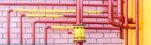 red gas pipes on a brick wall